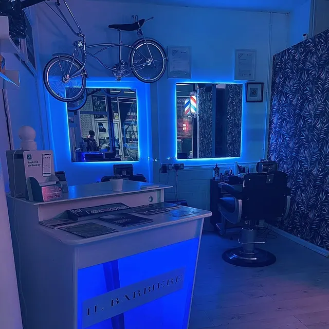The shop lit blue, a bicycle on the wall above the stations